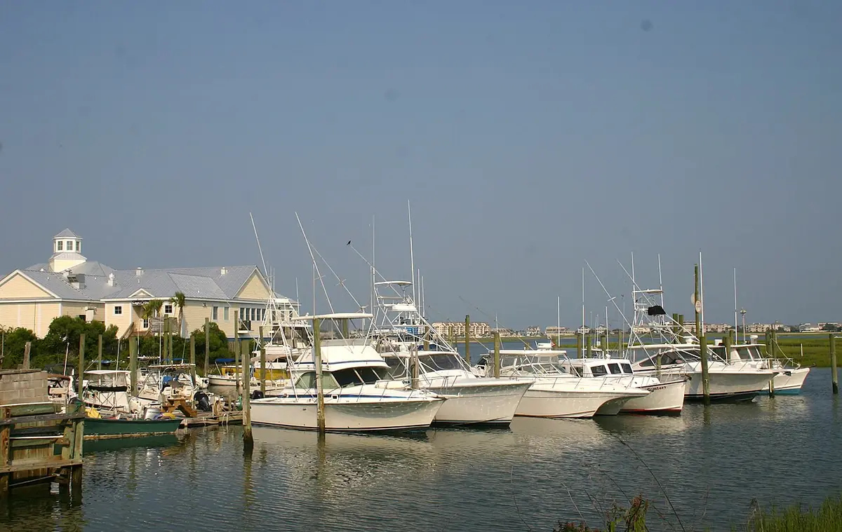 White fishing boats tied up at a marina on calm water in Murrells Inlet, South Carolina
