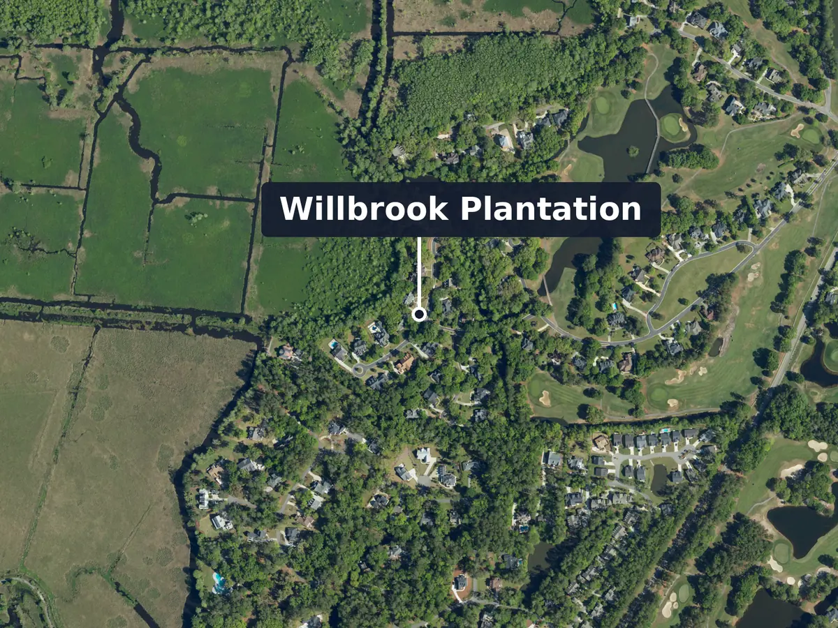 Willbrook Plantation from above, labelled: houses among trees beside golf fairways and a pond, open fields cut by ditches at the upper left, and more houses at the lower left; label: Willbrook Plantation