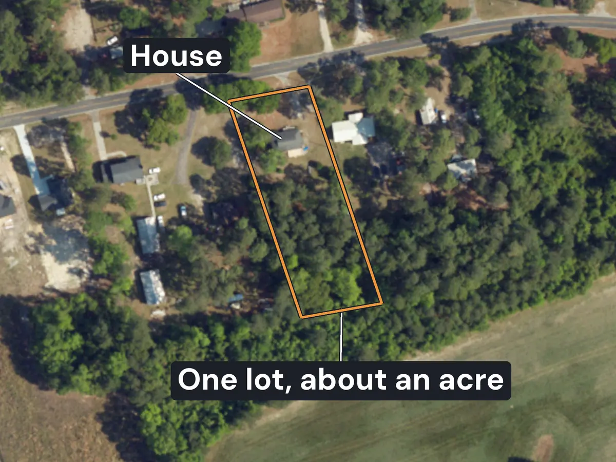 A country road outside Aynor from above, with houses on wide lots among pine trees and fields; one deep lot of about an acre is outlined in orange, with its house labelled near the road